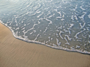 Sea wave on sand background